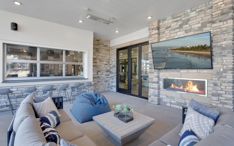 a patio area with a fireplace, couch and a tv